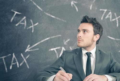 man with tax written in chalk behind him